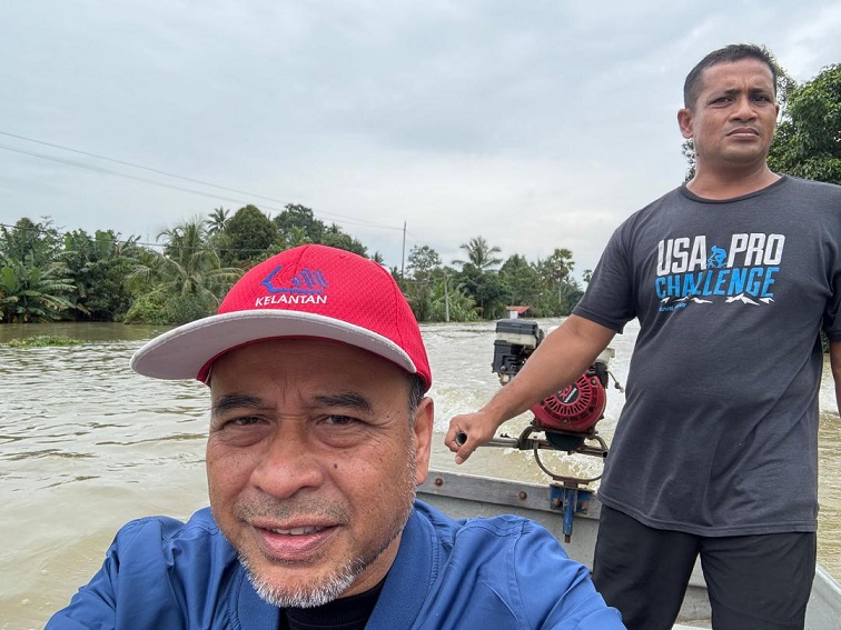 Datuk Mohd Rosdi Ab Aziz on a boat during the recent floods in Kelantan.